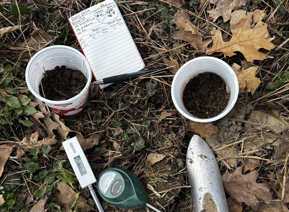 Soil sample cups next to a moisture meter and a field notebook
